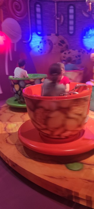 Kind im Karussell, den Tassen aus Alice im Wunderland nachempfunden. Verschwommen