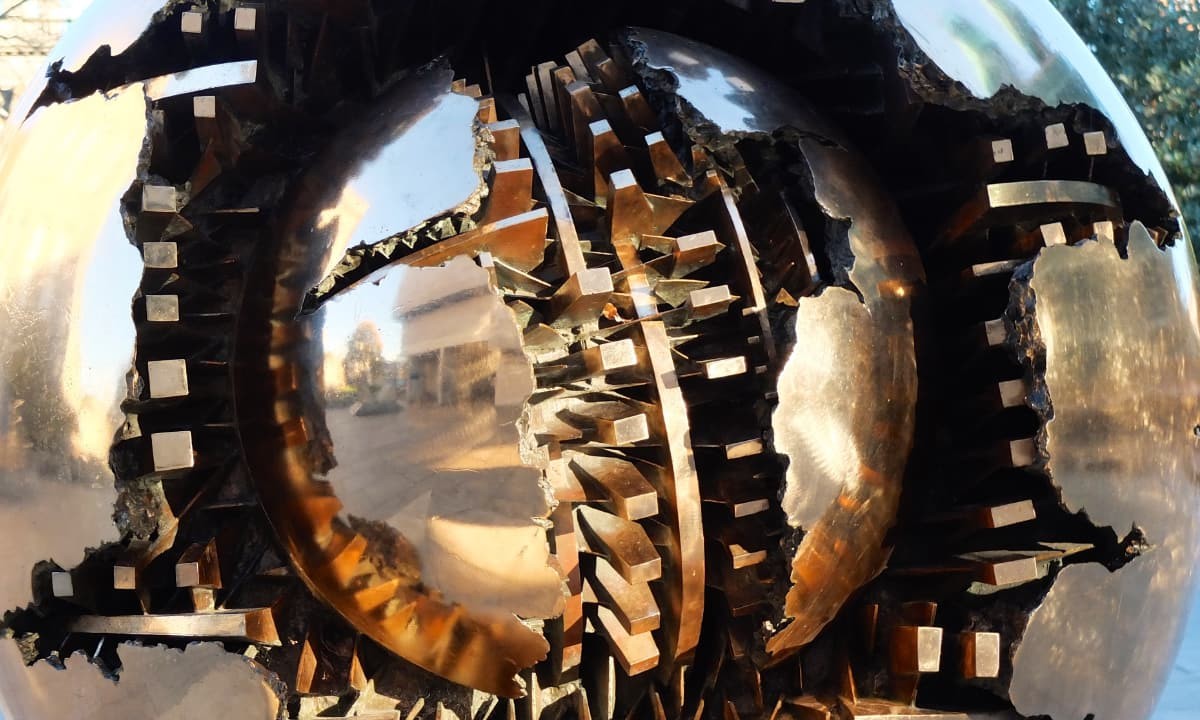 A brass sculpture with cracked sphears and gears