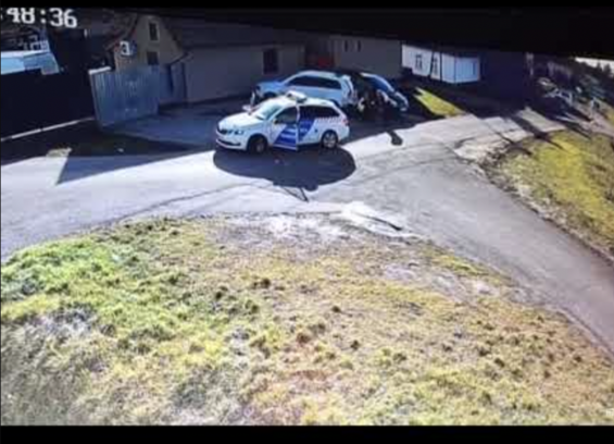 CCTV footage of a police car on a street with doors opened
