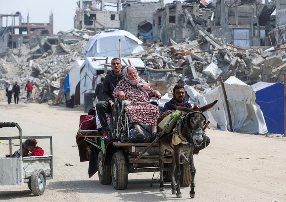 An old woman fleeing on a donkey cart; next to it is a mini trailer with two small children.