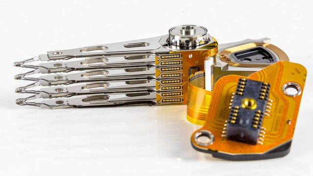 4-fach-Schreib-Lesekopf. Links die eigentlichen Kpfe, rechts eine orangefarbene, flexible Platine mit dem Anschluss nach aussen