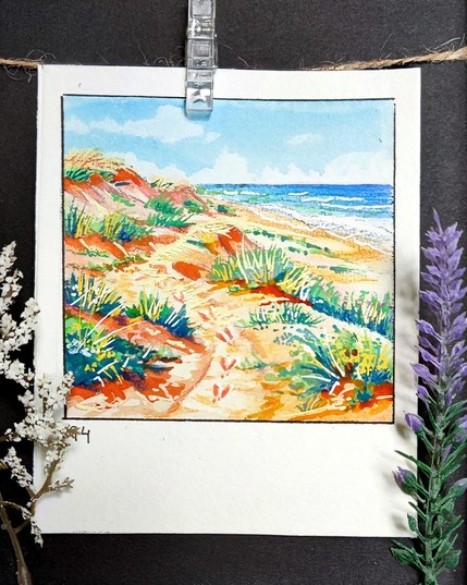 Square watercolor framed with a black line on a rectangular, portrait-oriented paper. A sandy path winds through sunlit dunes, dotted with tufts of green grass and patches of warm, earthy tones. Tiny pawprints trail along the path, leading toward the distant shoreline, where gentle waves meet the horizon. Above, a bright blue sky with soft clouds stretches over this peaceful coastal scene. Number 94 is written in the bottom left corner.