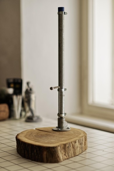 Photograph of a DIY clay stand, made of a wooden base and metal pipes.