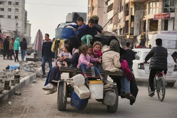 Displaced Palestinians, including children, flee at the back of a cart.