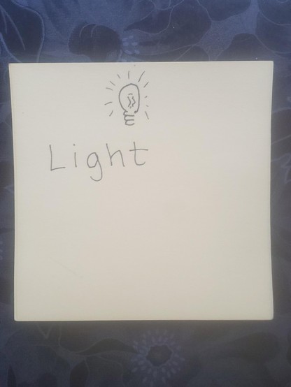 A post it note with the word LIGHT and a tiny lightbulb illustration
