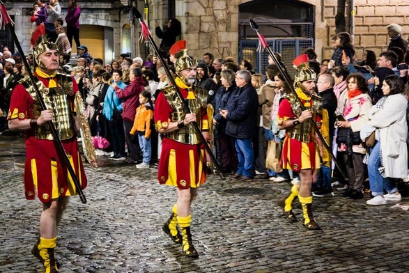 Roman soldiers marching on a street.