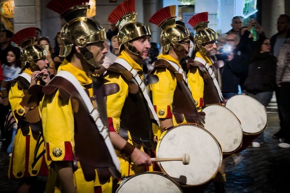 Roman soldiers marching on a street.