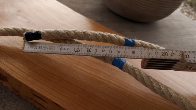 der Schaukelsitz mit dem Seil das an den Spleißstellen bereits mit Klebeband markiert wurde, mit Meterstab um zu sehen das 15cm aufgetrennt werden sollen