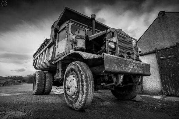 Monochrome shot of old dump truck, worn out and rusted