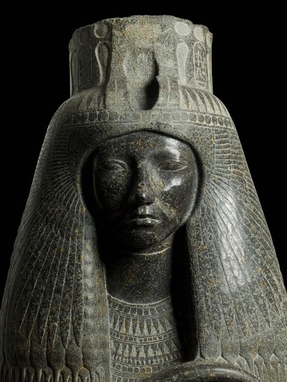 a photo , the statue's face from her chest up, looing at the viewer, she is wearing a necklace