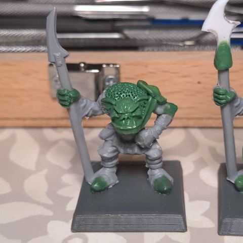 An in progress shot of a plastic model orc with various areas re-sculpted in epoxy putty