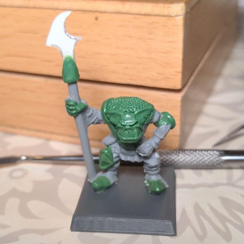An in progress shot of a plastic model orc with various areas re-sculpted in epoxy putty