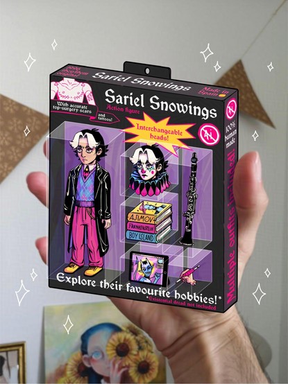 An illustration of an action figure box pasted onto a picture of Sariel’s hand so it looks like they’re holding the box. The action figure is a miniature version of sariel, they’re wearing a black leather coat,  a blue, purple and pink argyle sweater vest and pink pants. They have black hair with a white strand on the front. The pack includes an extra head with clown makeup, three science fiction books, a clarinet and an iPad and an extra hand holding an Apple pen. The writing on the box says things like “interchangeable heads!” “With realistic top surgery scars… and tattoos!” “Multiple outfits included!” And so on