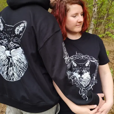 Photo représentant un couple portant les textiles illustrés par des têtes de renard blanches et de végétaux