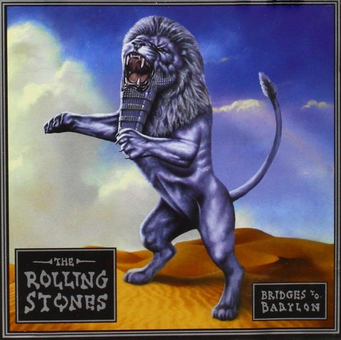 the cover  without the slip case, the lion is in a sandy desert,  a blue sky with clouds behind it