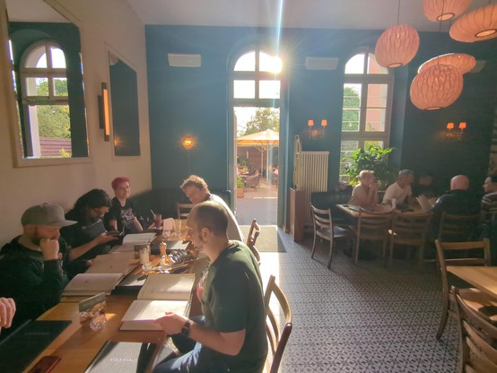 Multiple tables next to windows with the sunset shining through