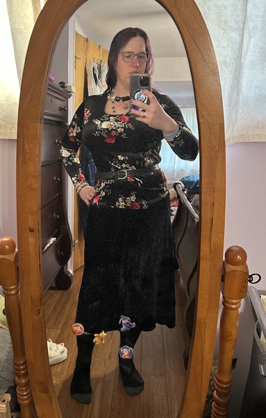Selfie of a lady wearing black posing in front of a mirror.