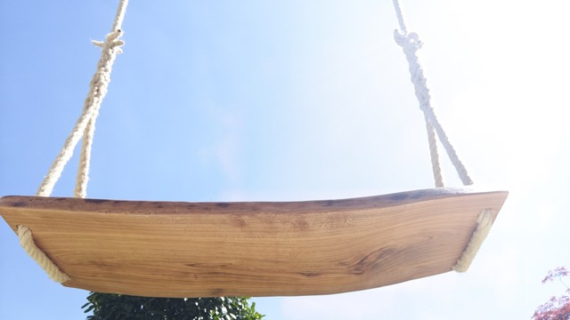 die selbstgebaute und -gespleißte Schaukl von unten, dahinter sind Sträucher und blauer Himmel zu sehen