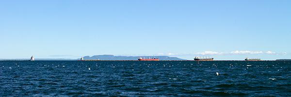 The horizon with the Sleeping Giant and the ships are just below the middle of the photo.
In the front is water and behind is a blue sky.