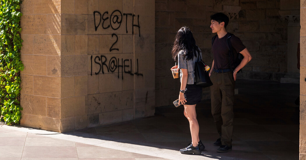 Students looking at a wall near the president’s office at Stanford University after it had been vandalized by protesters in June.