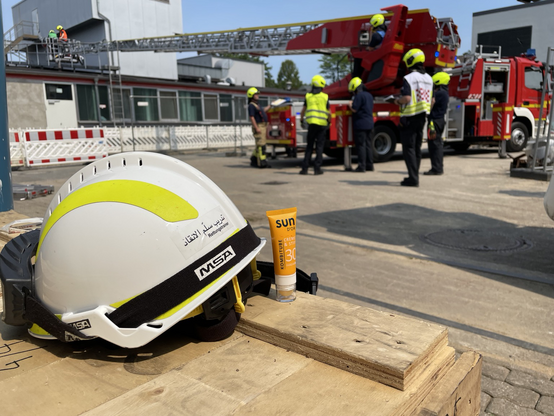 Feuerwehrhelm und Sonnencreme bei sonniger Einsatzübung
