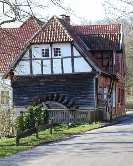 Fachwerkhaus mit Mühlrad davor
