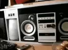 a row of speakers are sitting on top of a table next to a remote control .