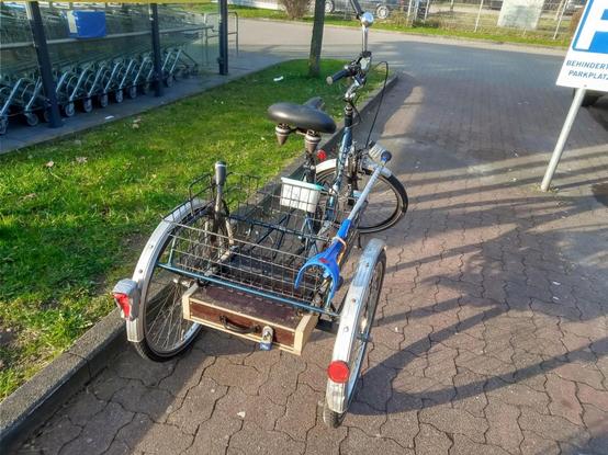 Das blaues Fahrrad mit zweispuriger Hinterachse von hinten