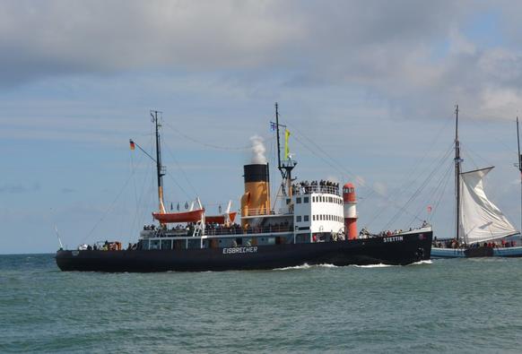 Eisbrecher STETTIN vor Warnemünde. Ein Schiff mit schwarzem Rumpf weißem Brückenaufbau und hohem gelben, oben schwarz abgesetztem Schornstein. 