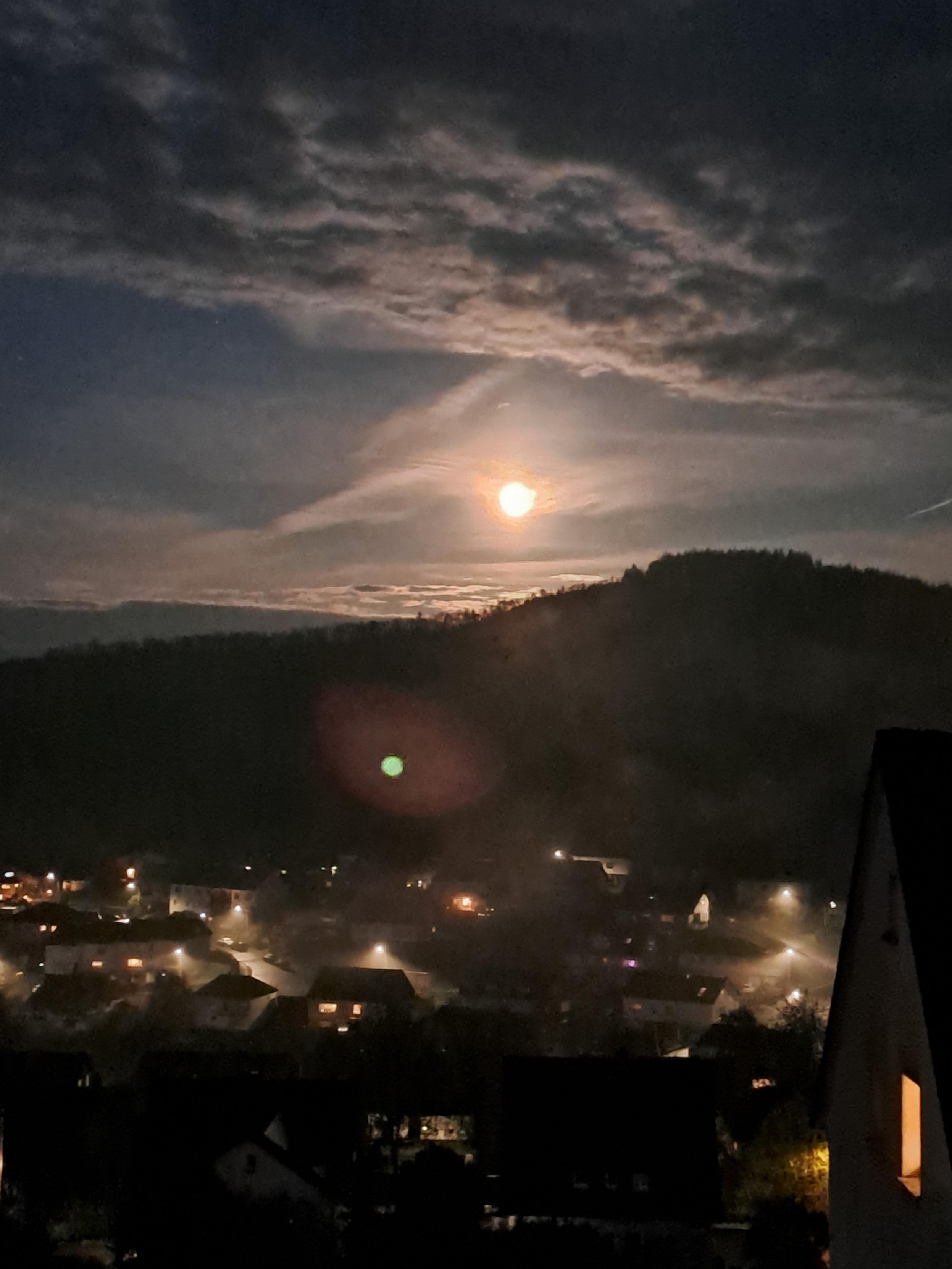 Mai Mond im Sauerland. Darunter eine Kleinstadt im Talnebel. Mai Mond im Sauerland. Darunter eine Kleinstadt im Talnebel.