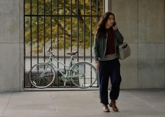 Die Tatortkommisarin nach dem sie ihr Fahrrad an einen Zaun geschlossen hat.