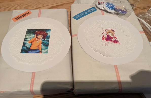 Zwei Manga, eingewickelt in Geschenkpapier, verziert mit Stickern.