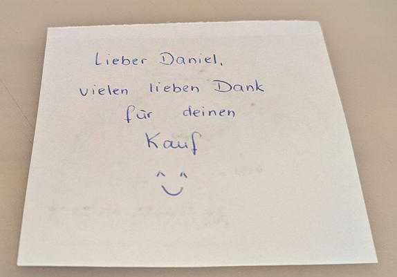 Ein Zettel, auf dem "Danke für Deinen Kauf" steht.