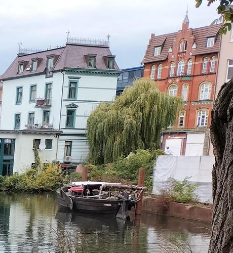 UNS EWER im Bergedorfer Hafen. Im Hintergrund Wohnhäuser und einige Bäume.
