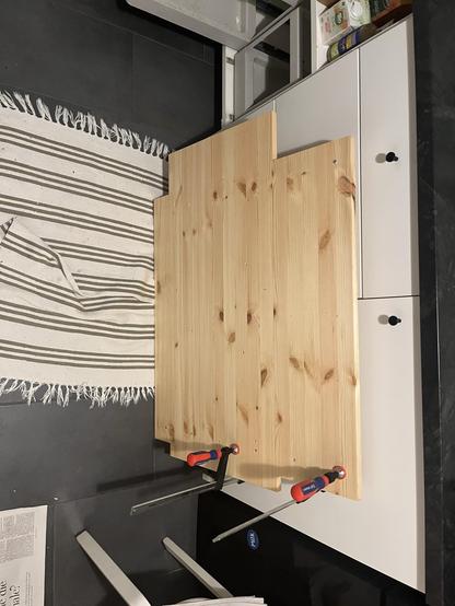 Ein Brett voller Schraublöcher, mit ein paar Schrauben und Schraubzwängen. Alles wirkt etwas zusammengeklatscht und null professionell.