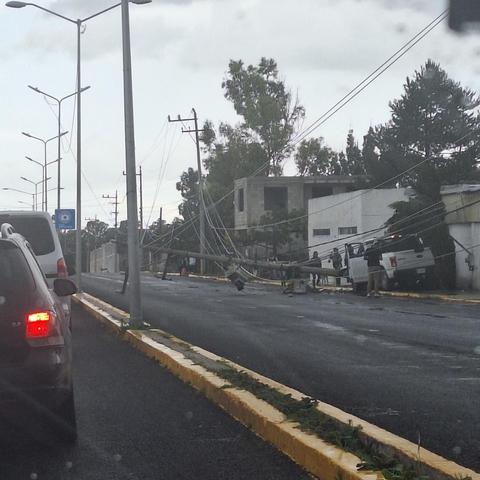 Ein abgeknickter Strommast liegt auf der Straße, ein weißer pick-up truck ist anscheinend reimgefahren.