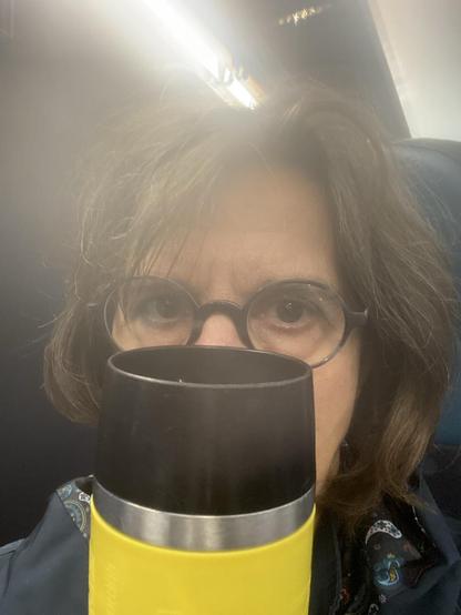 ich verstecke mich im Zug hinter meinem gelben Kaffeebecher. Man sieht nur meine Augen hinter der Brille und ein paar Haare. Und den gelben Kaffeebecher.