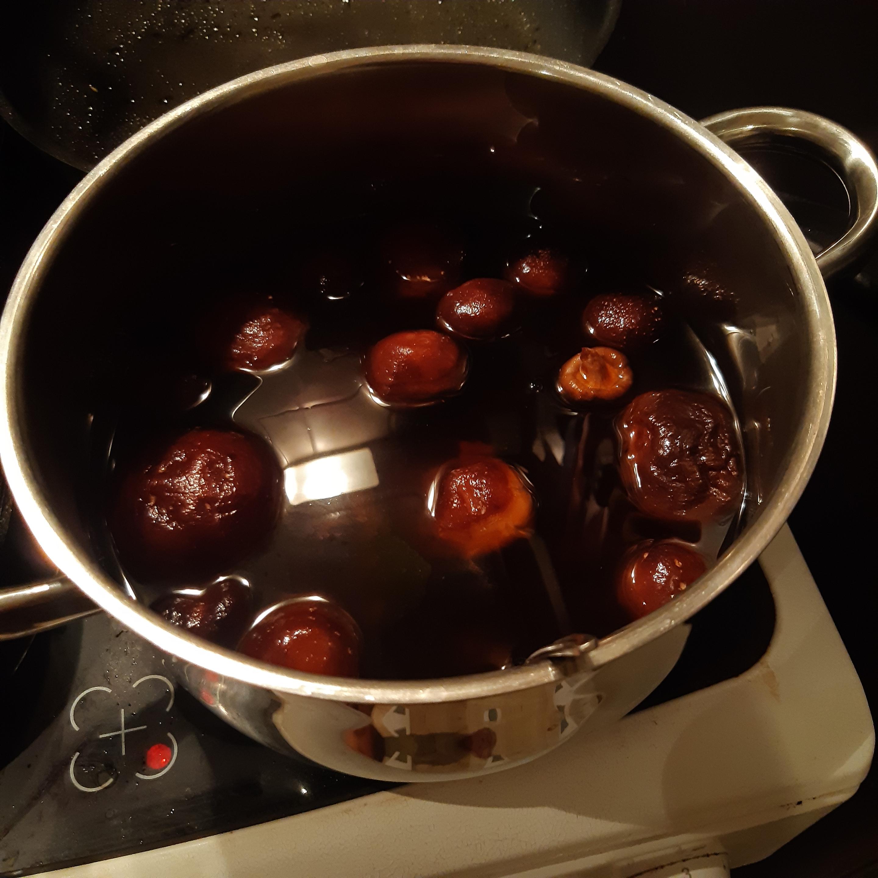Veganes Shiitake-Dashi wurde zuvor vorbereitet und nun mit Misosuppenpaste aufgerührt und befindet sich in einem Topf. Die Algen wurden auch bereits hinzugefügt.