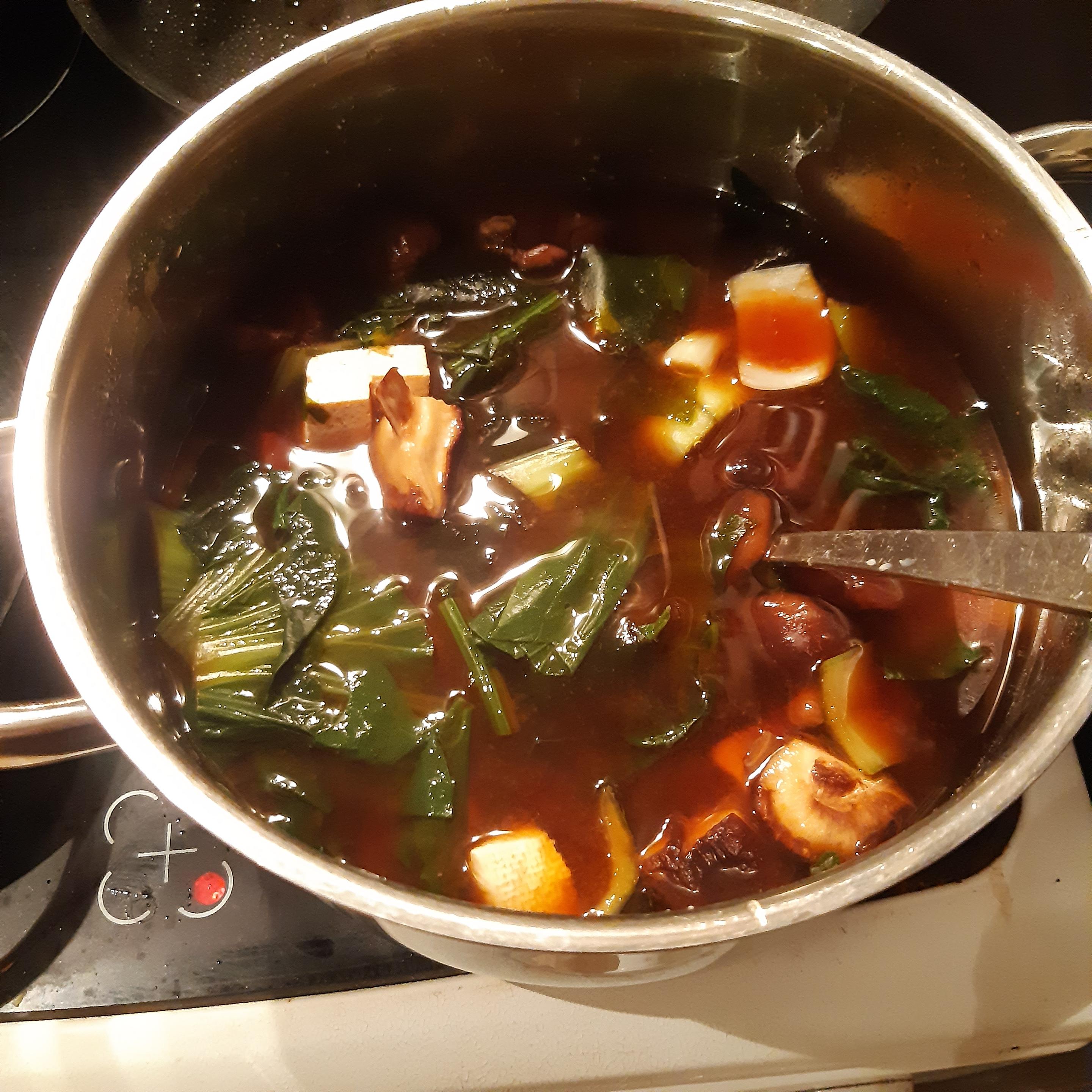 Fertige Misosuppe in einem Topf: Pak Choi, Spinat und Tofu wurden hinzugefügt.
