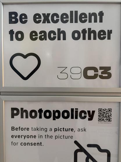 Das Bild zeigt den Text „Be exzellent to each other“ („Seid ausgezeichnet zueinander“) in fettgedruckten schwarzen Buchstaben, gefolgt von einem schwarzen Herzumriss-Symbol und dem Text „39C3“ (wobei „39“ in einem leichteren Stil und „C3“ in einem fetteren Stil erscheint).