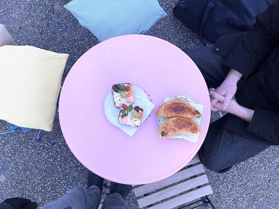 Zwei Teller auf einem Tischen mit bunt belegten Broten und Empanadas