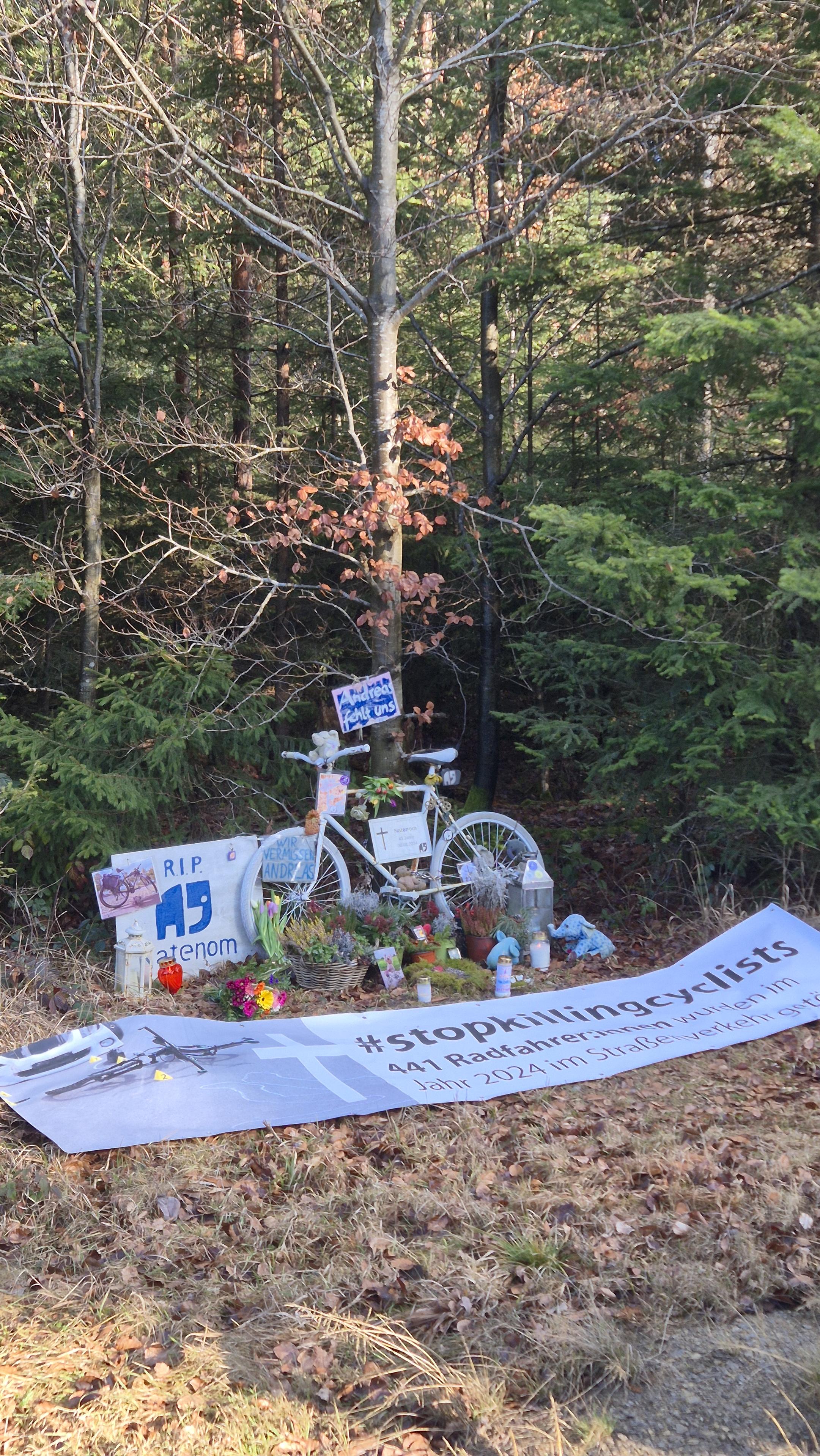 Die Gedenkstätte für Natenom neben der Landstraße mit dem Ghostbike, Blumen und einem Banner das an seinen Tod erinnert.