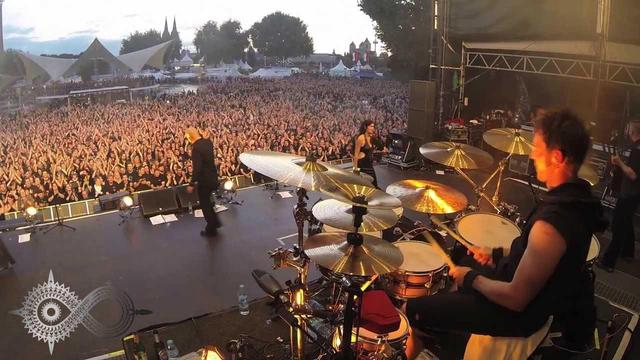 Aufnahme einer Bühne auf der die Band Schandmaul vor Open Air Publikum spielt.