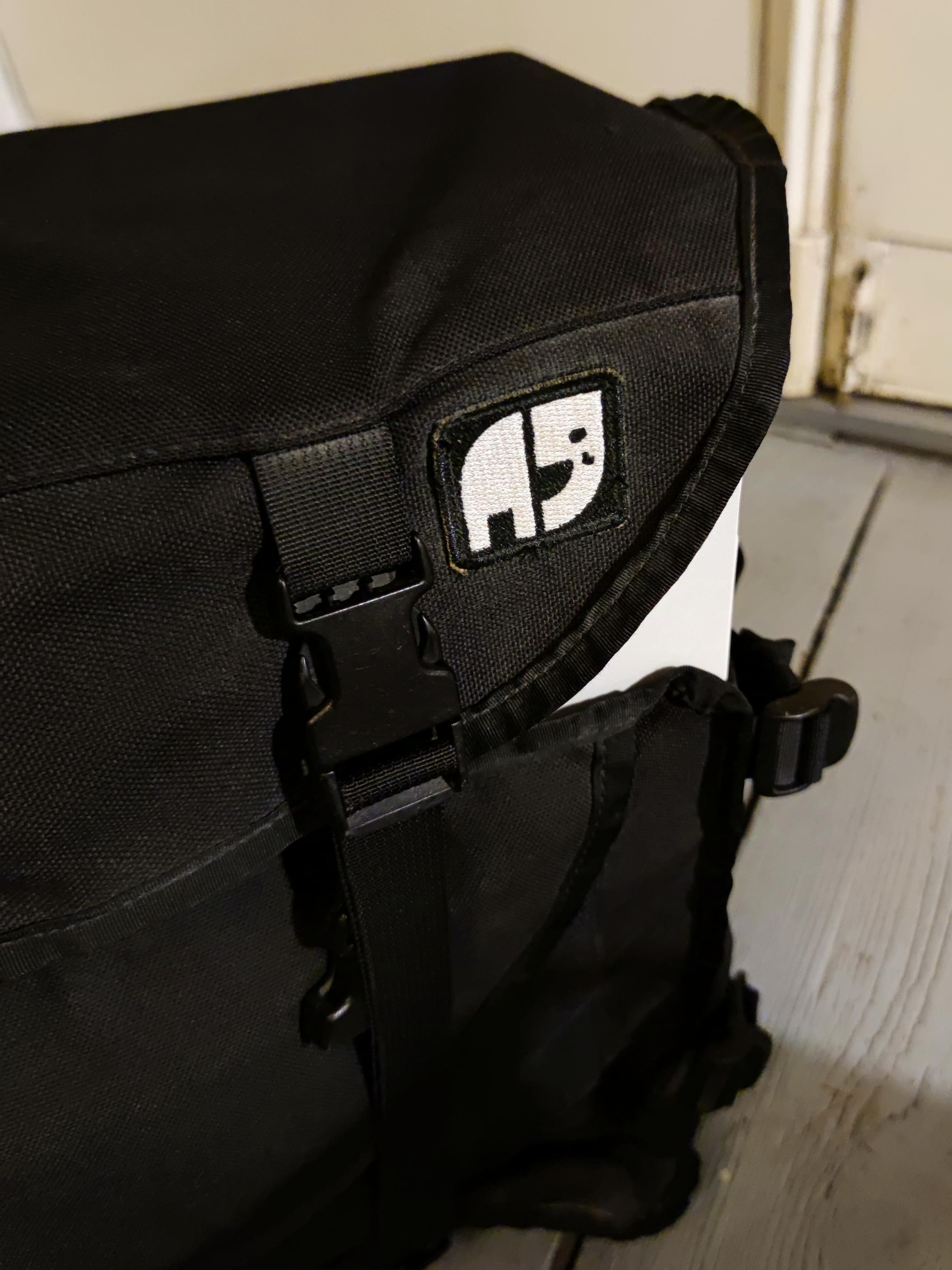 Detailaufnahme der Kuriertasche. Darauf befindet sich ein Aufnäher mit einem stilisierten Elefanten, dem Logo des von einem Autofahrer totgefahrenen Fahrradaktivisten Natenom. Der Elefant hat eine Träne im Auge.