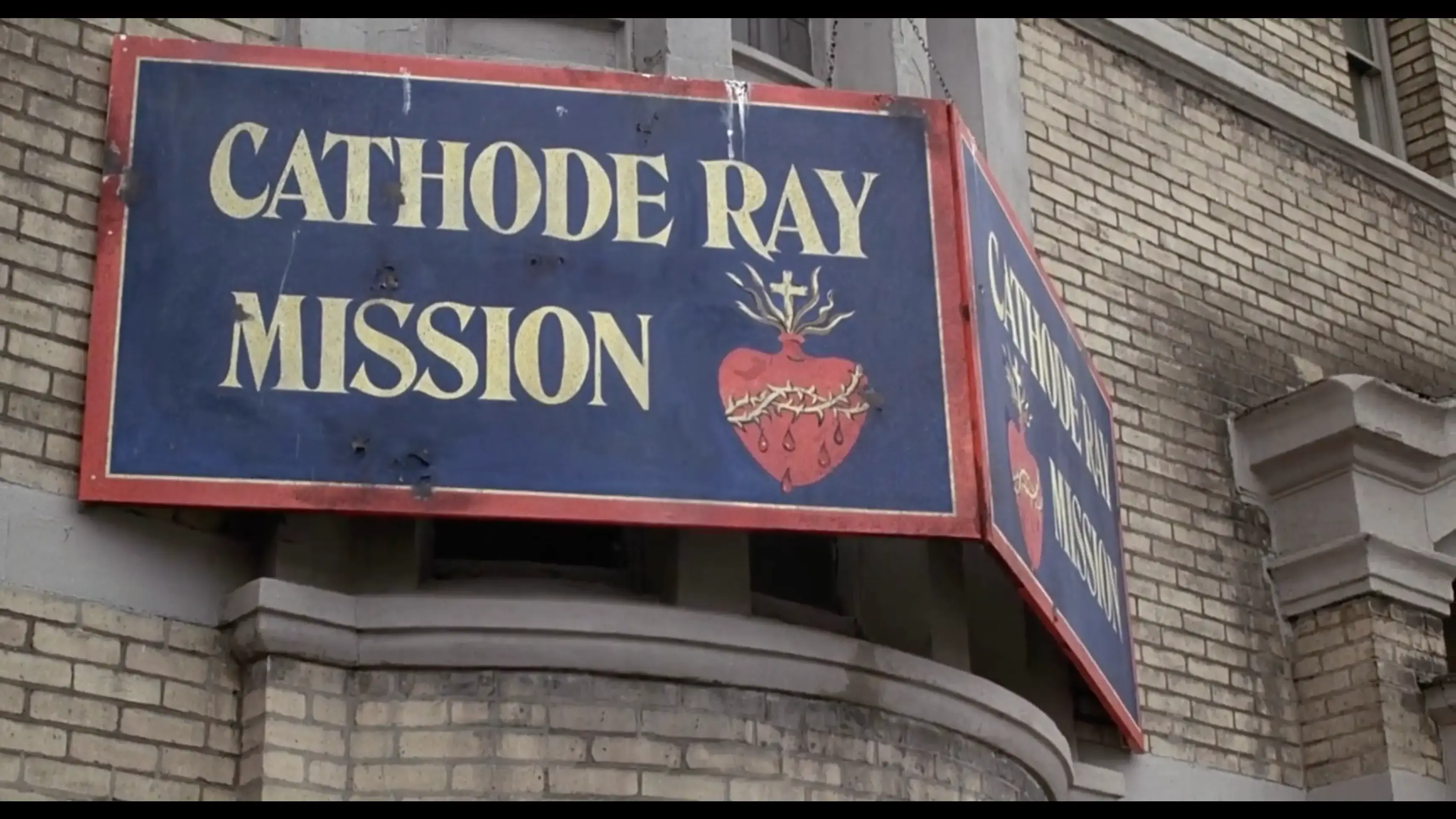 Signage on a yellow brick building: CATHODE RAY MISSION.