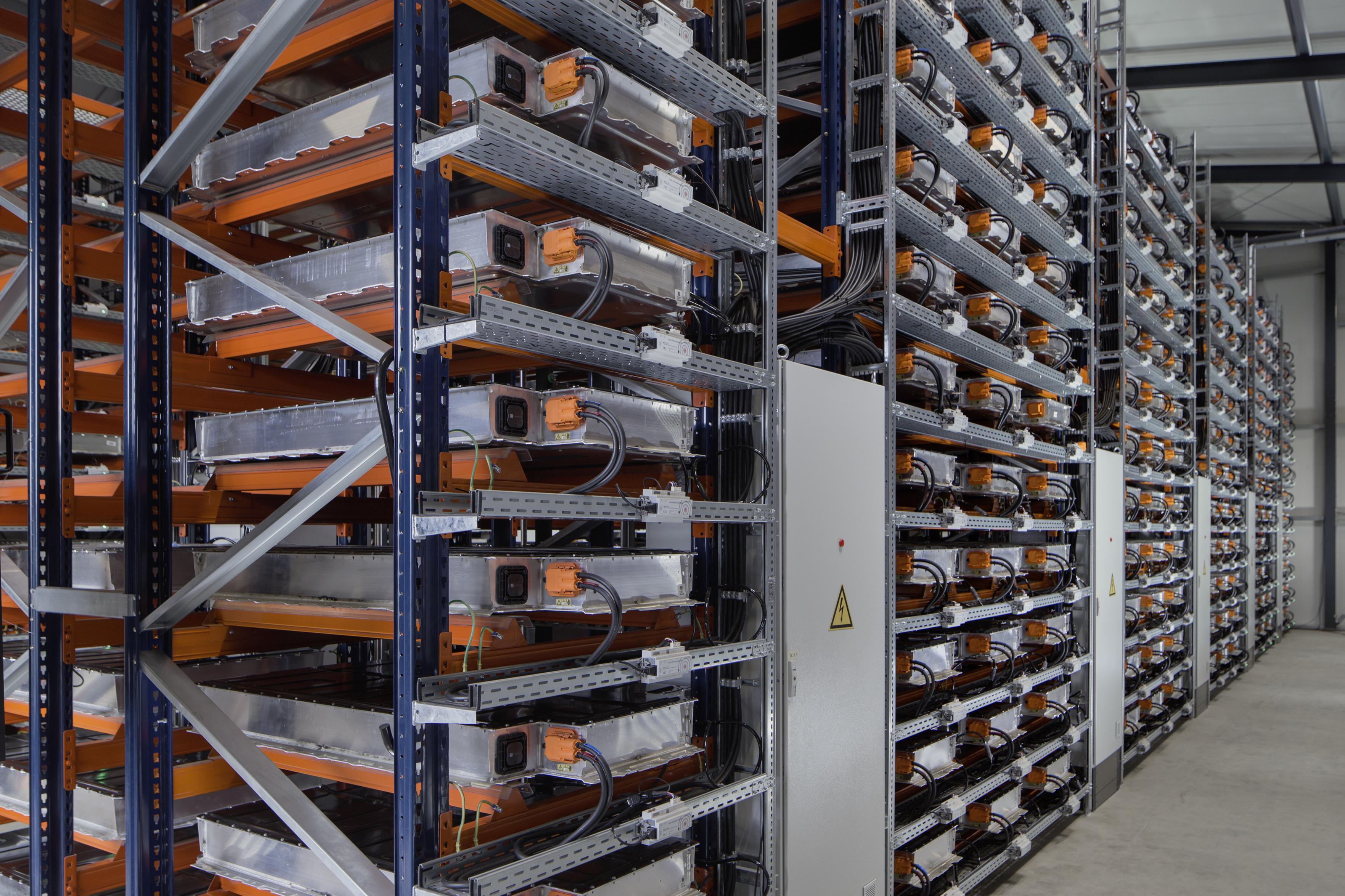 A warehouse filled with neatly organized battery storage units on metal racks, highlighting a focus on energy solutions.