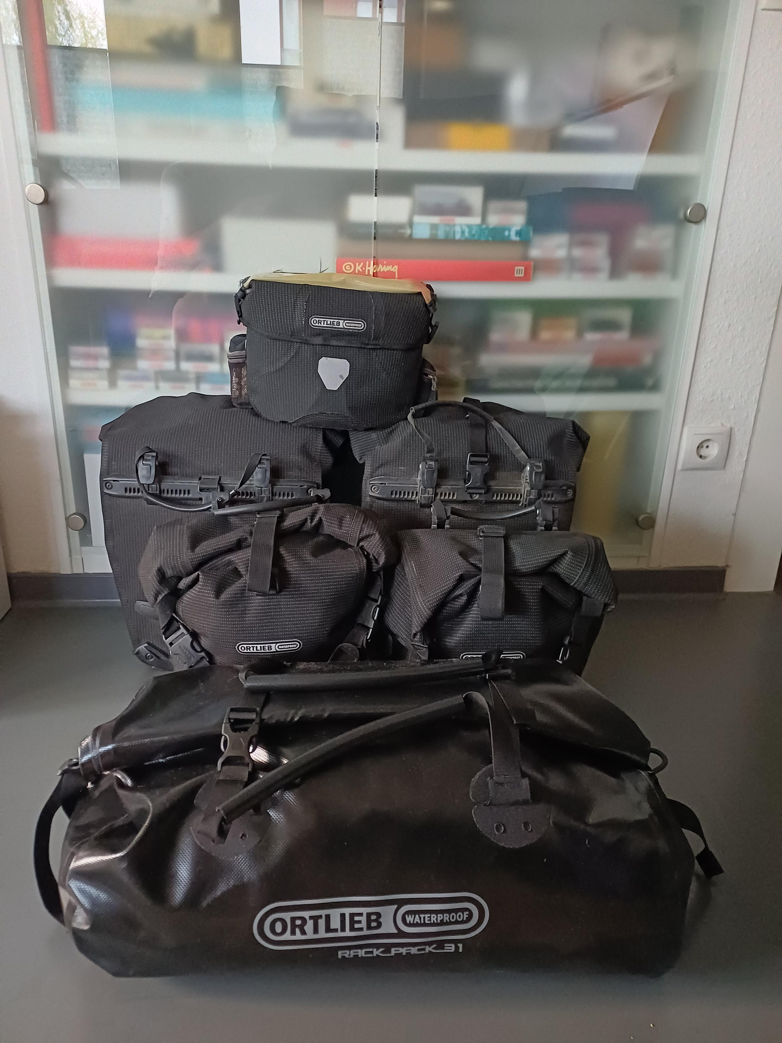 Sechs voll gepackte schwarze Gepäckstücke fürs Fahrrad