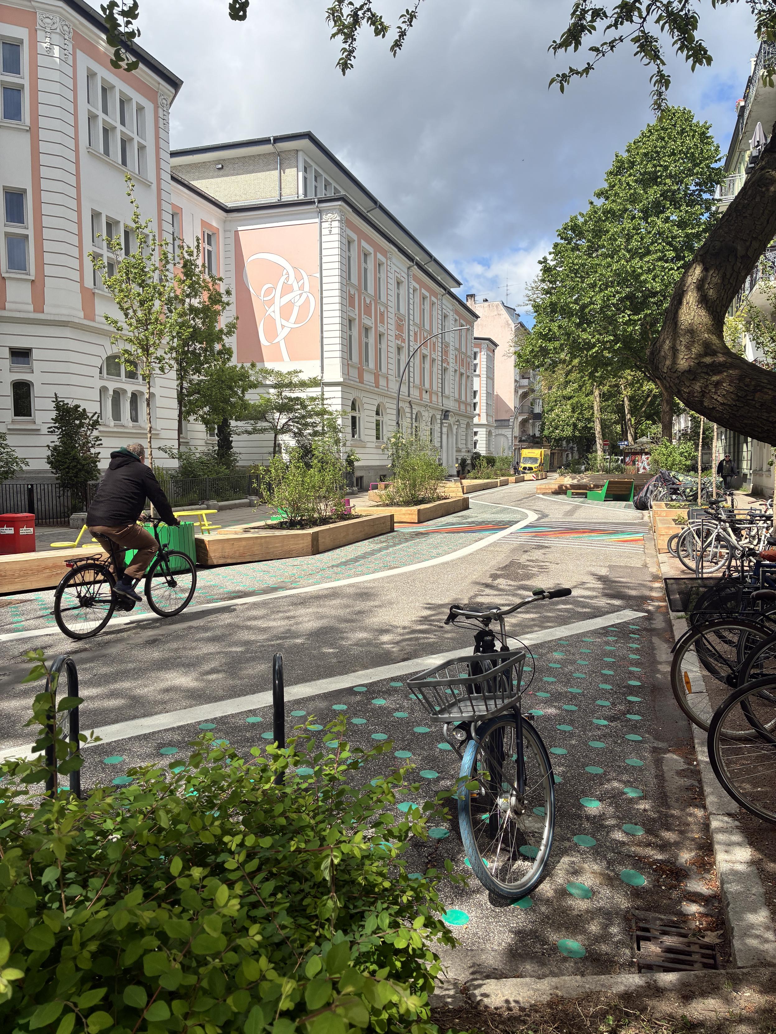 Foto der umgestalteten Rellinger Straße mit Fahrradstellplätzen und Radverkehr