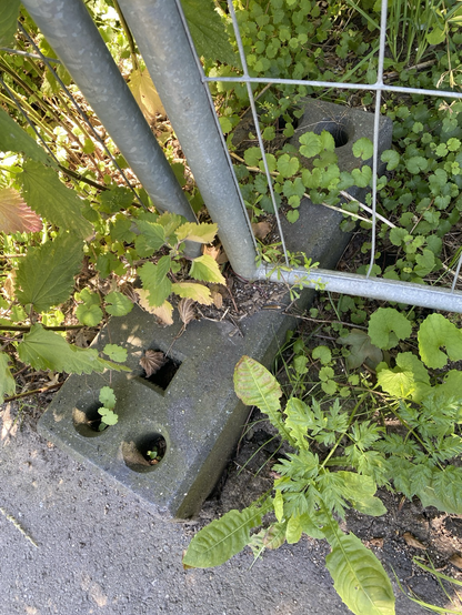 ein schwarzes, quaderförmiges Ding aus Beton. Es dient dazu, mobile Zäune festzuhalten und am Umkippen zu hindern.