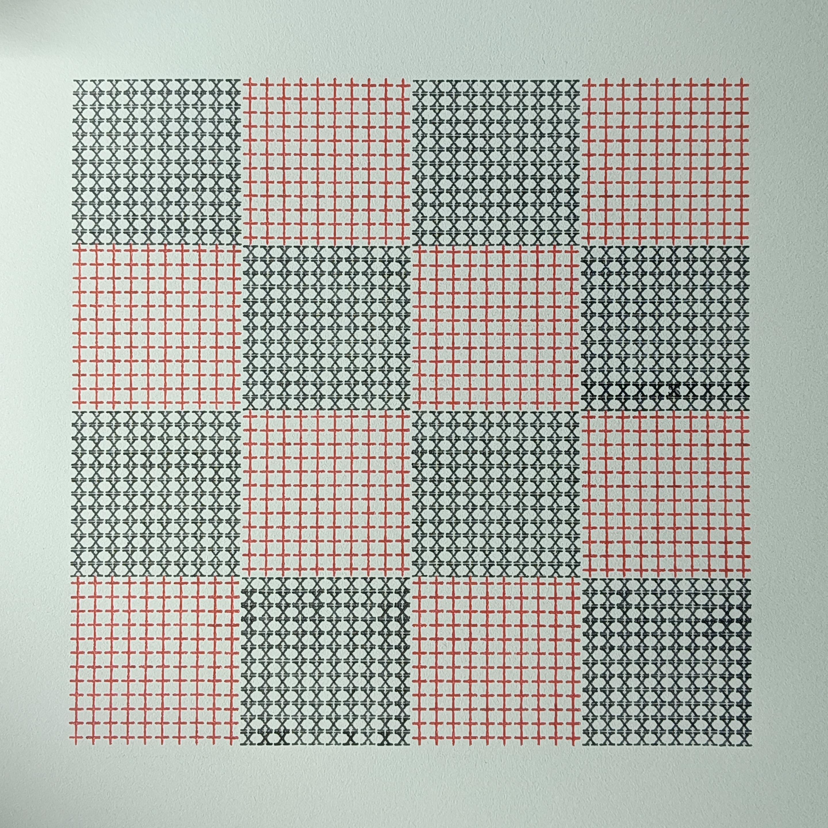ein Schachbrettmuster, maschinengeschrieben in schwarz und rot mit dem Buchstaben x (schwarz) und + (rot)